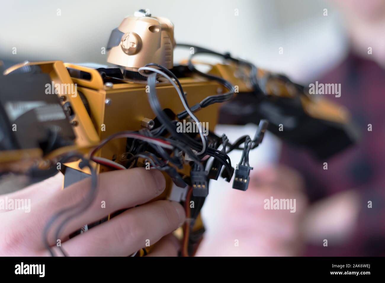 Young woman engineer working on robotics project. Scientist engineer designs small human robot, settings artificial intelligence humanoid robot Stock Photo