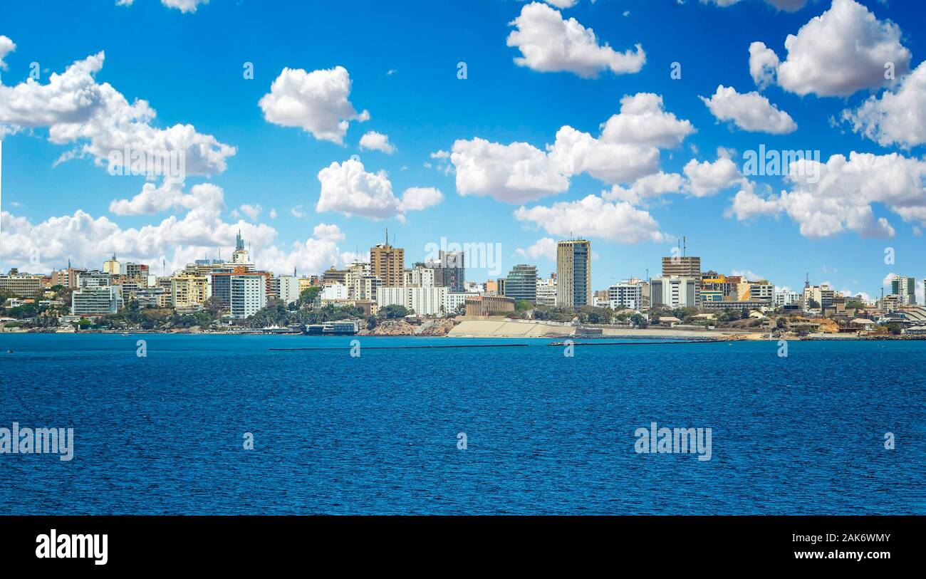 View of the Senegal capital of Dakar, Africa. It is a city panorama taken from a boat. There are large modern buildings and a blue sky with clouds. Stock Photo