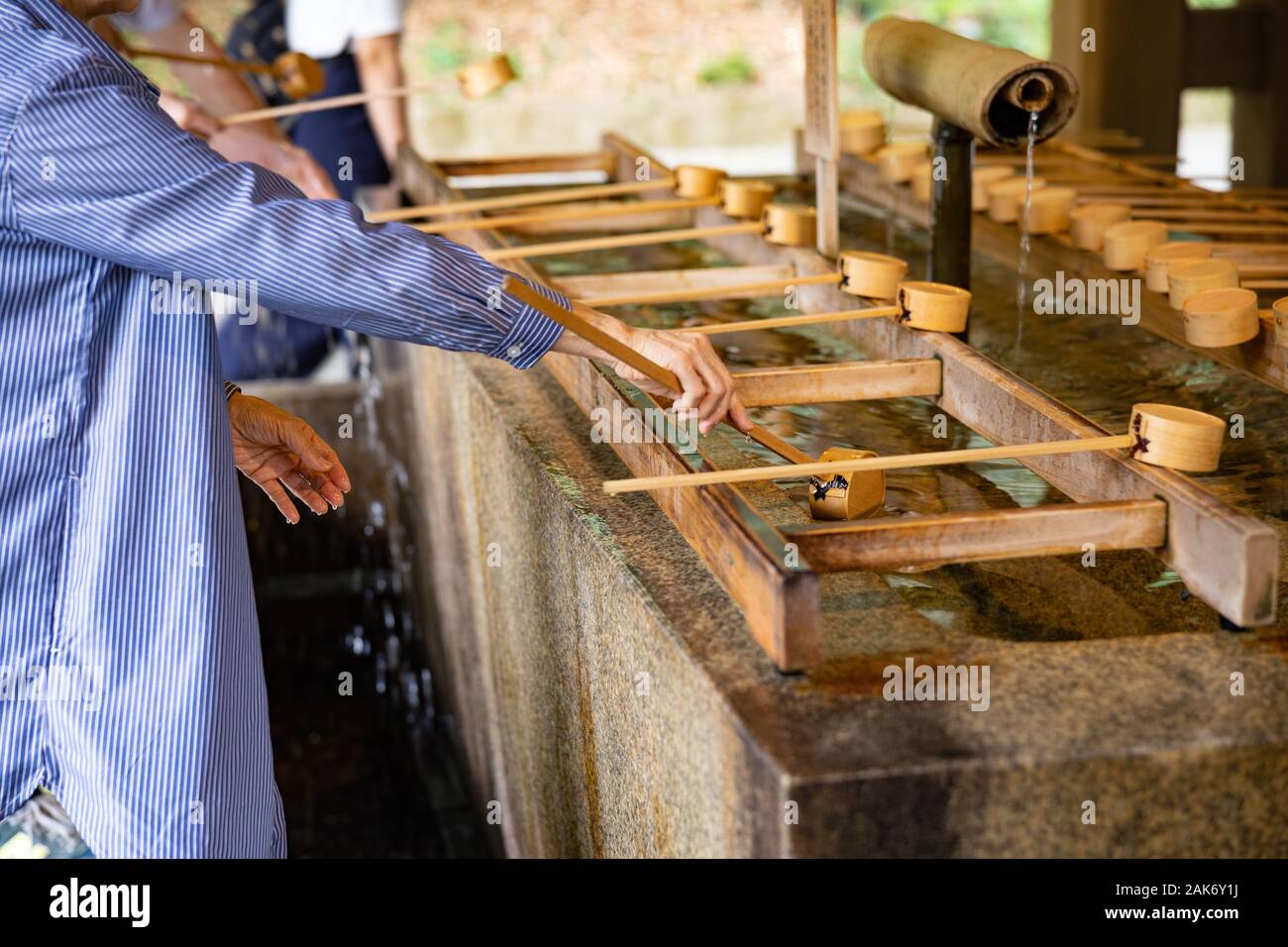 Woman with traditional ladle in Buddhist temple Stock Photo