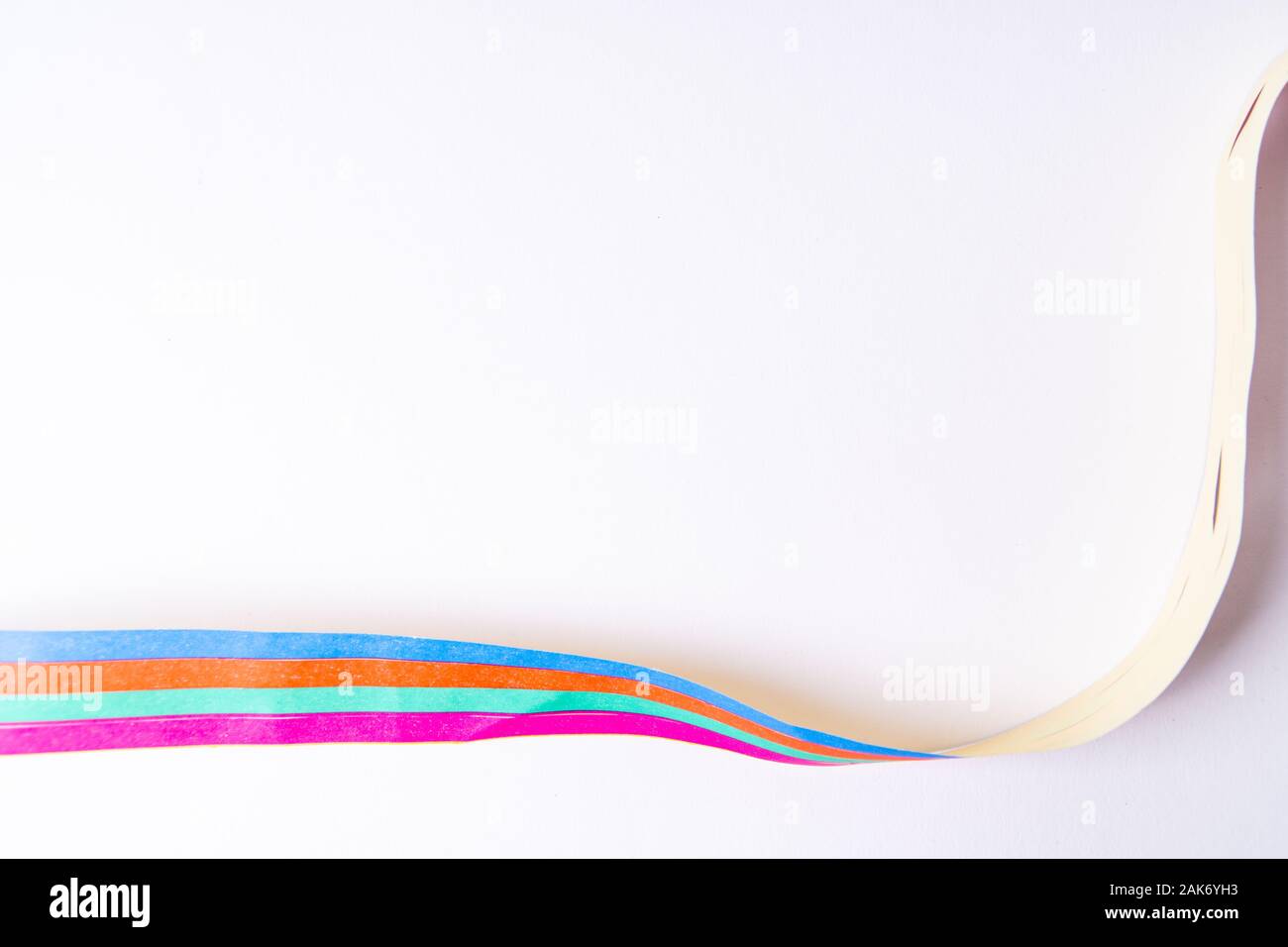 A paper streamer laying on white background Stock Photo - Alamy