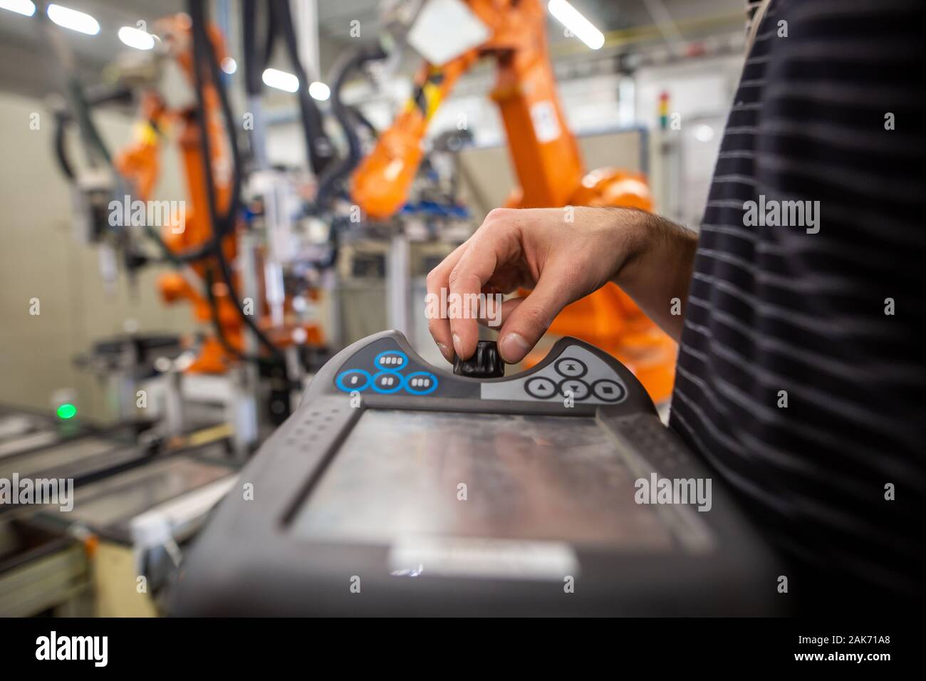 Man programming robot in automotive industrial, professional programmer ...