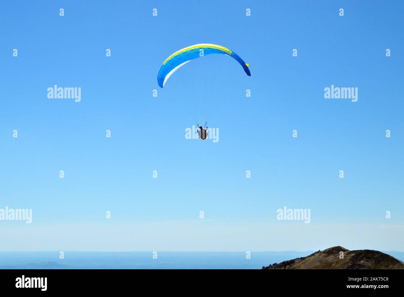 Paraglider flies on top of a volcanic mountain. This is extreme sport Stock Photo