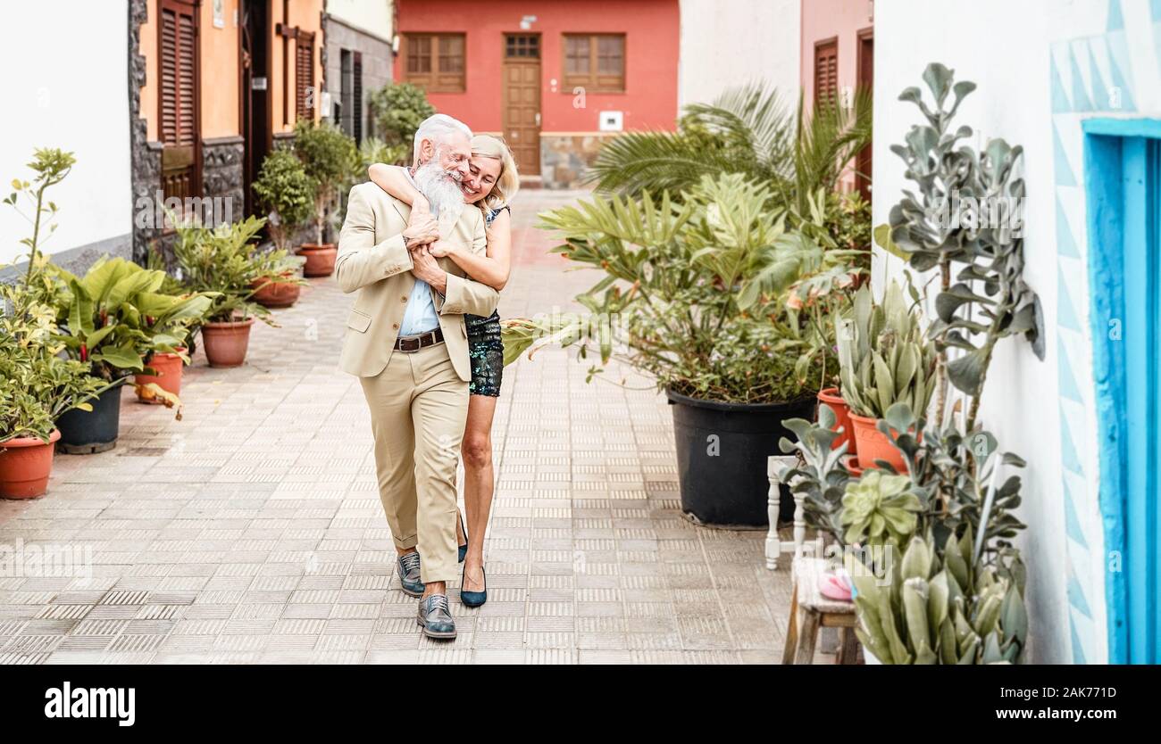 Happy senior couple embracing outdoor - Retired people having fun walking in the city - Love, relationship and elderly lifestyle concept Stock Photo