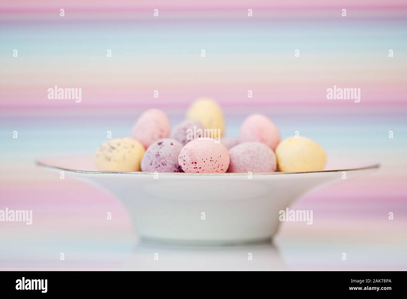 Sugar shell covered chocolate eggs in small dish Stock Photo