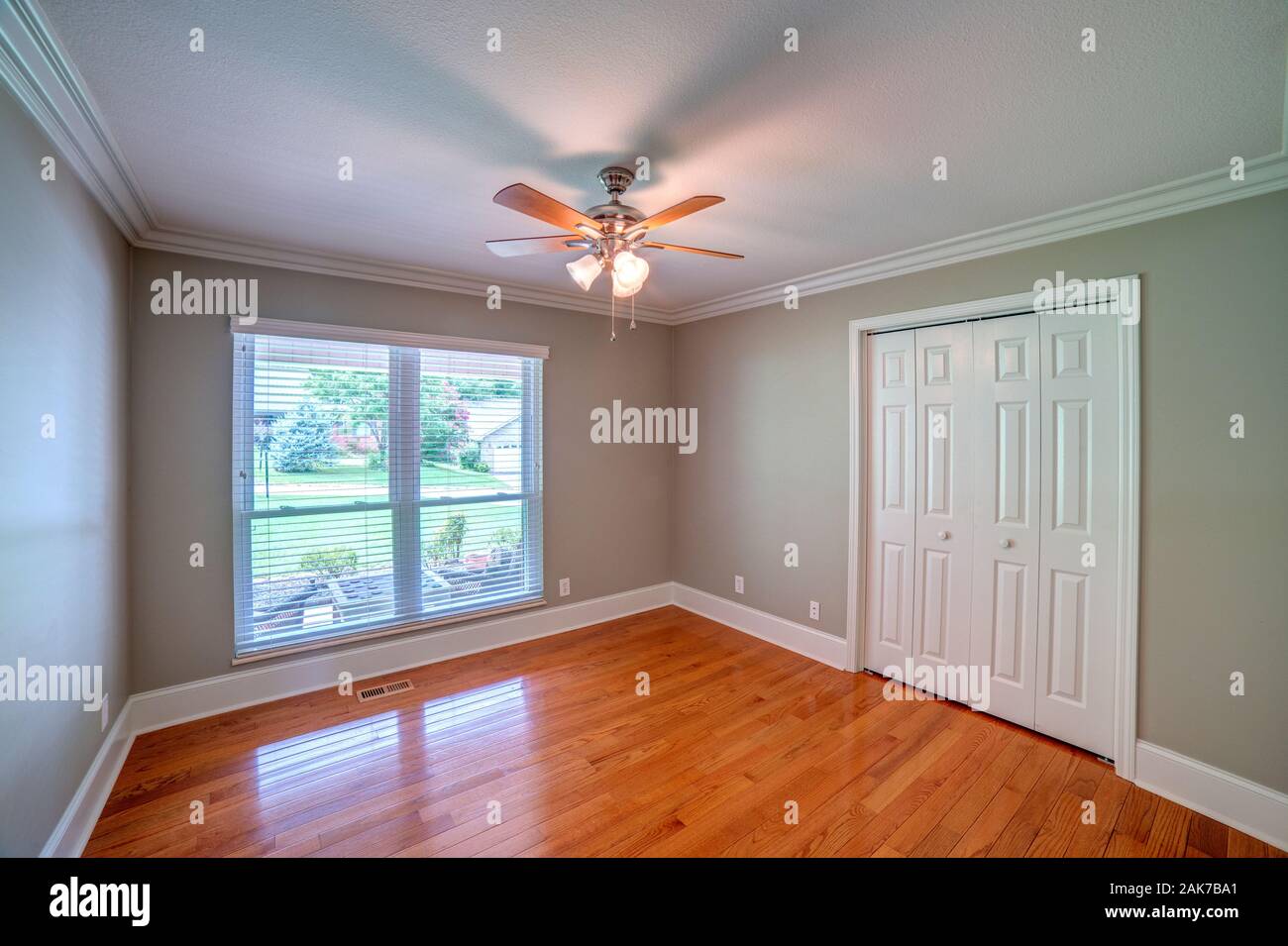 Horizontal shot of an empty bedroom with wood flooring. Stock Photo