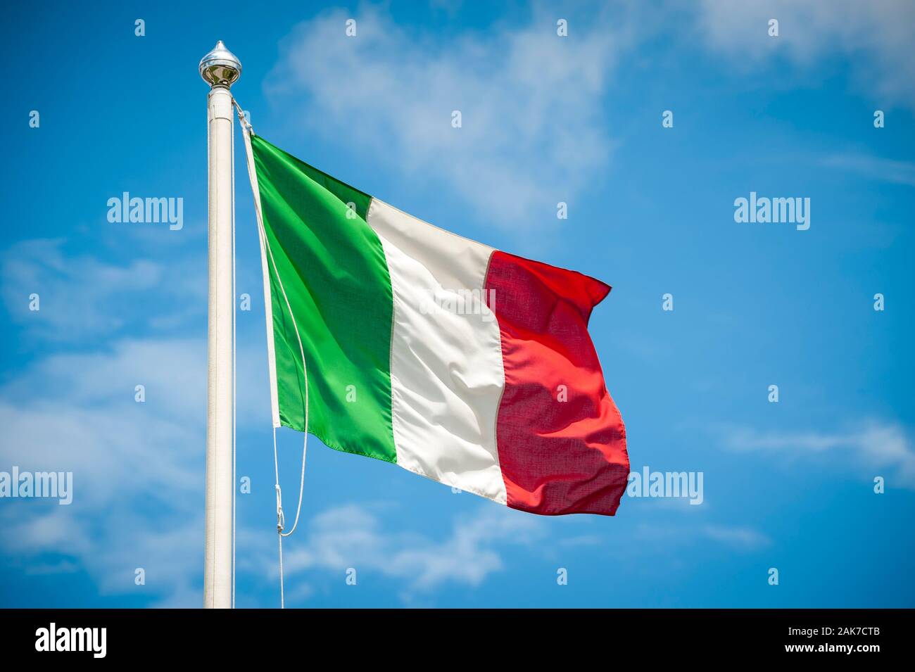 Flag of Italy blowing in bright Mediterranean sun on a flagpole