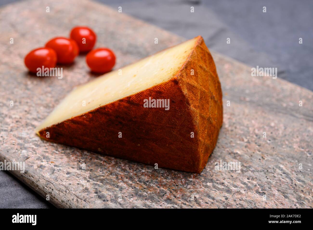 Cheese collection, piece of Spanish manchego cheese made from cow milk with red paprika close up