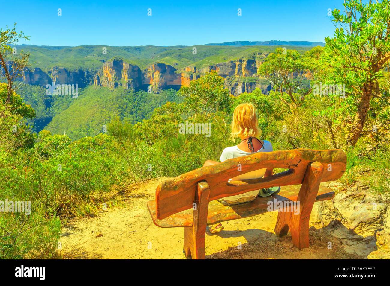 Caucasian tourist woman sitting on wooden bench, looking panoramic