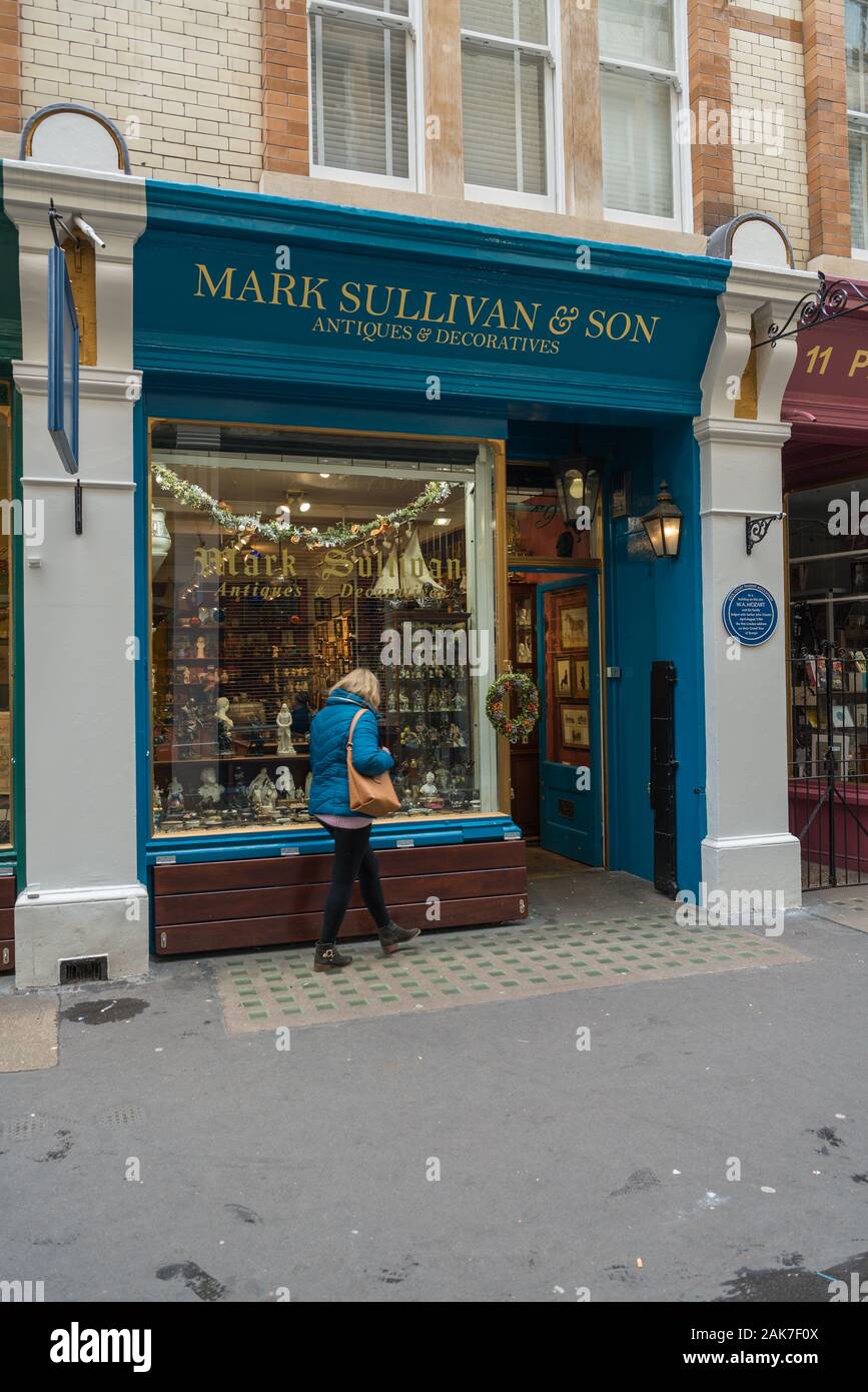 A lone woman looks in the window of the Mark Sullivan antiques shop in Cecil Court, Covent Garden, London, England, UK Stock Photo