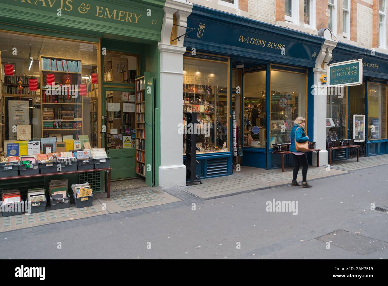 Lone woman walking past Watkins bookshop in Cecil Court, near Covent Garden, London, England, UK Stock Photo