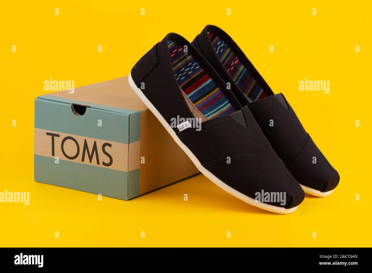 A pair of Toms Shoes from the company's Venice Collection appears by a  branded shoebox shot on a yellow background Stock Photo - Alamy