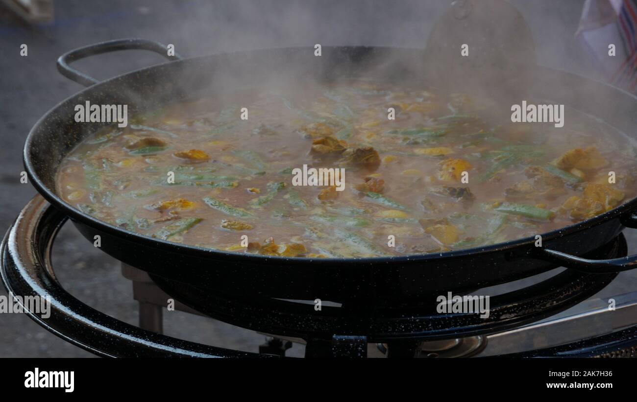 Cooking a delicious paella outdoors in the village of Cullera, which is located in the community of Valencia, in Spain, Europe Stock Photo