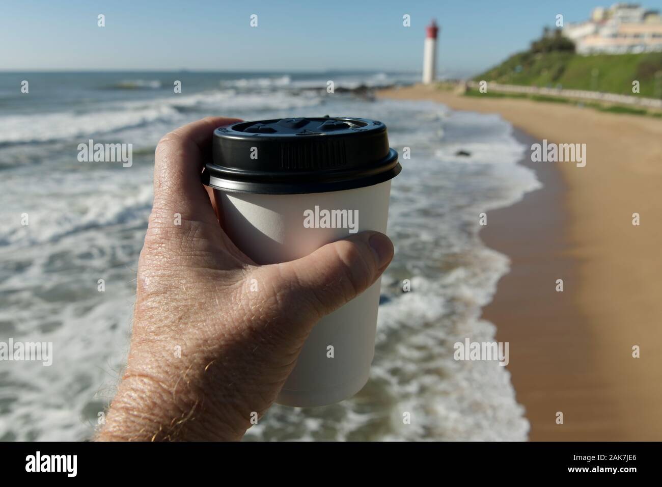 Durban, South Africa, concept, plastic pollution, hand of Author holding single use disposable cup, beach of Umhlanga Rocks waterfront, object Stock Photo