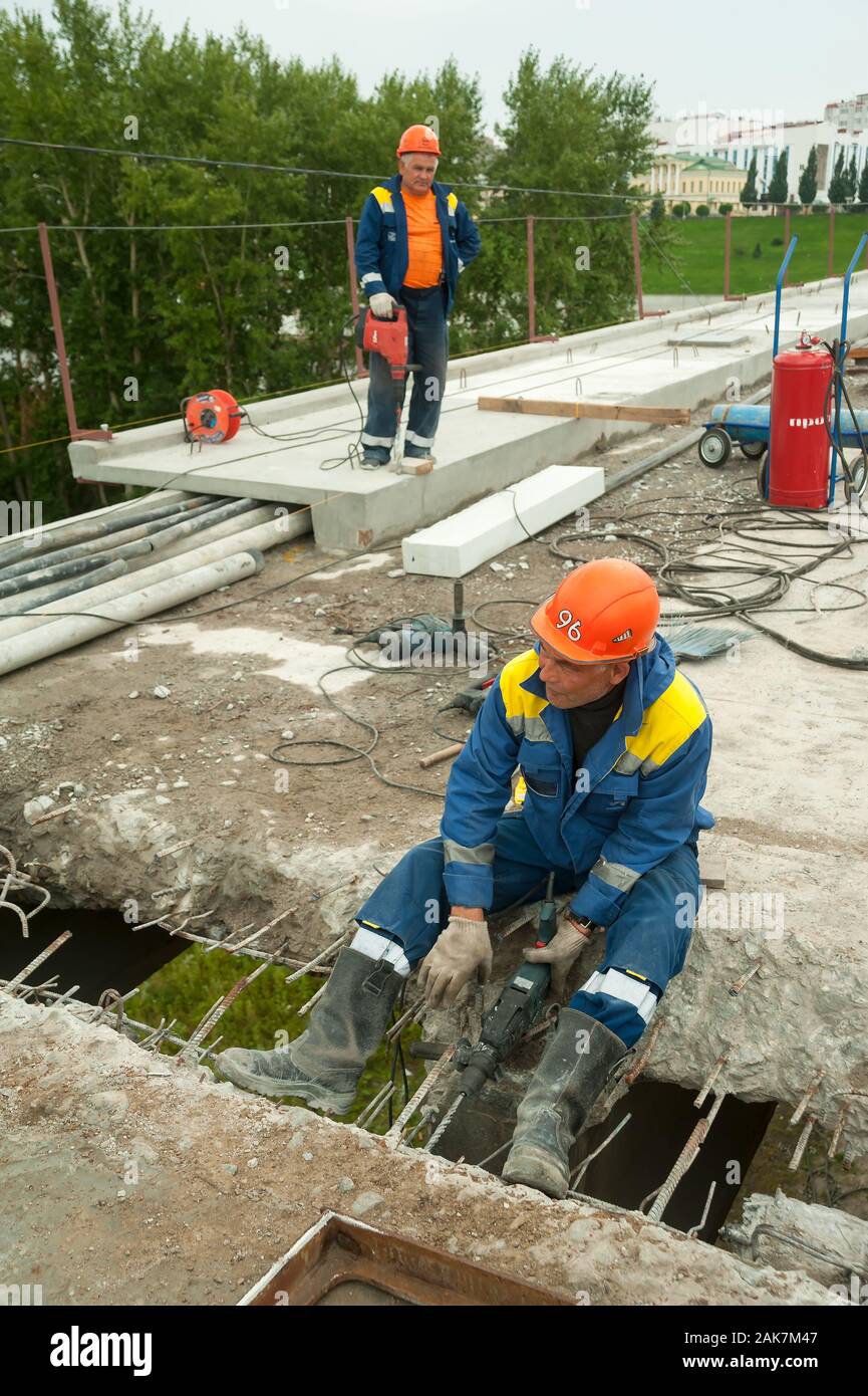 Worker with jackhammer to break up concrete Stock Photo