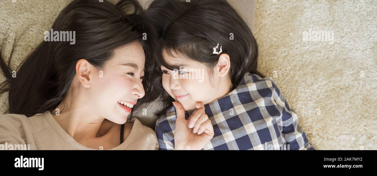Mother and daughter child girl spending time together in the bedroom Look at each other and smiling .Happy Asian family Stock Photo