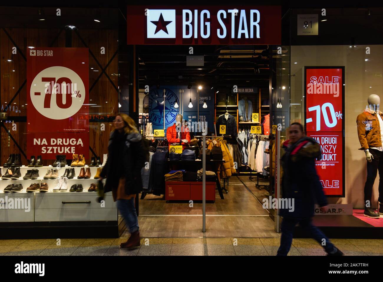 People walk pass a Big star shop in Krakow. Stock Photo