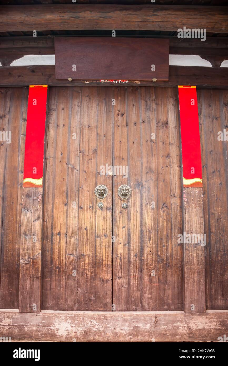 The empty wooden Plaque and Spring Festival couplets without text on the traditional chinese wooden door with brass handle during the Chinese New Year Stock Photo