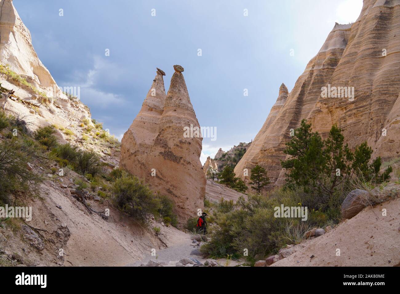 A hiking trail winds along the canyon floor next to the cone shaped spires of the Tents Rock National Monument. Stock Photo