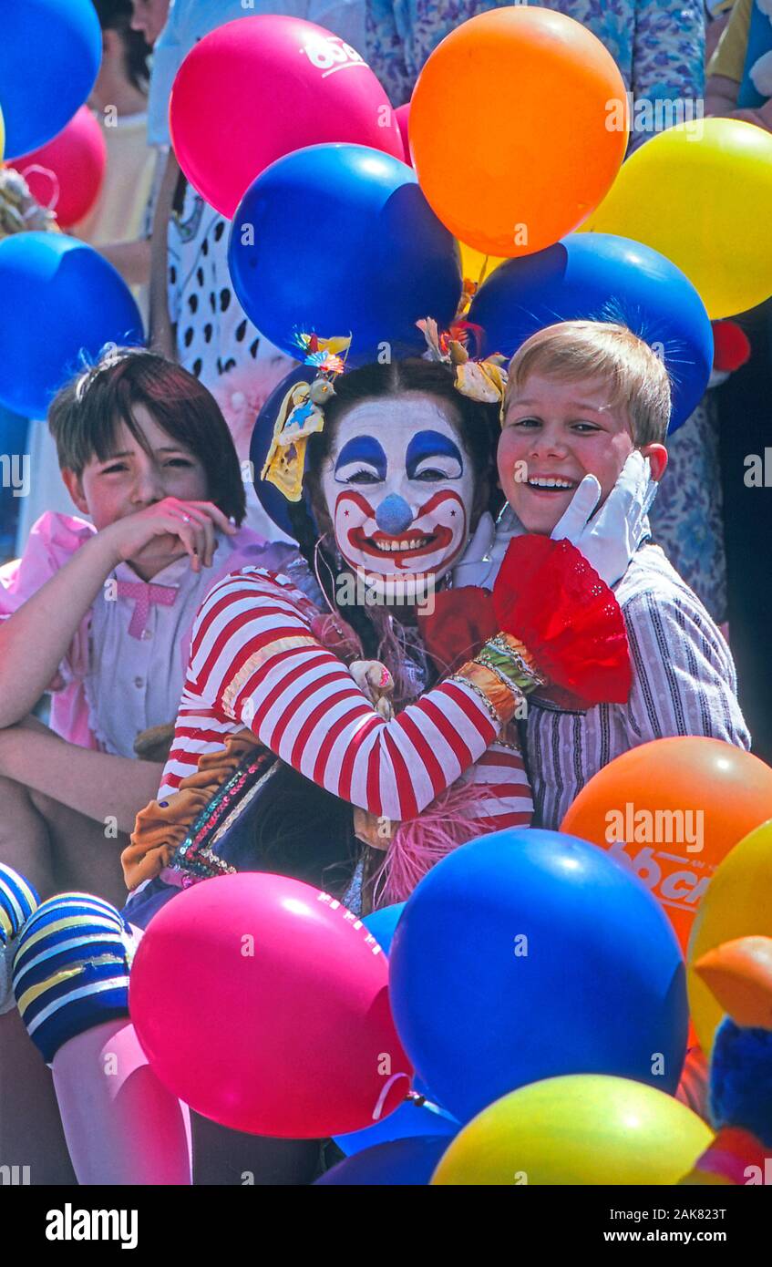 Female clown posing and laughing with two children Stock Photo