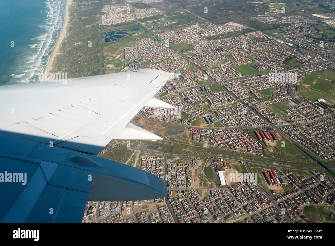 an aerial view, looking down from a plane window over the wing of