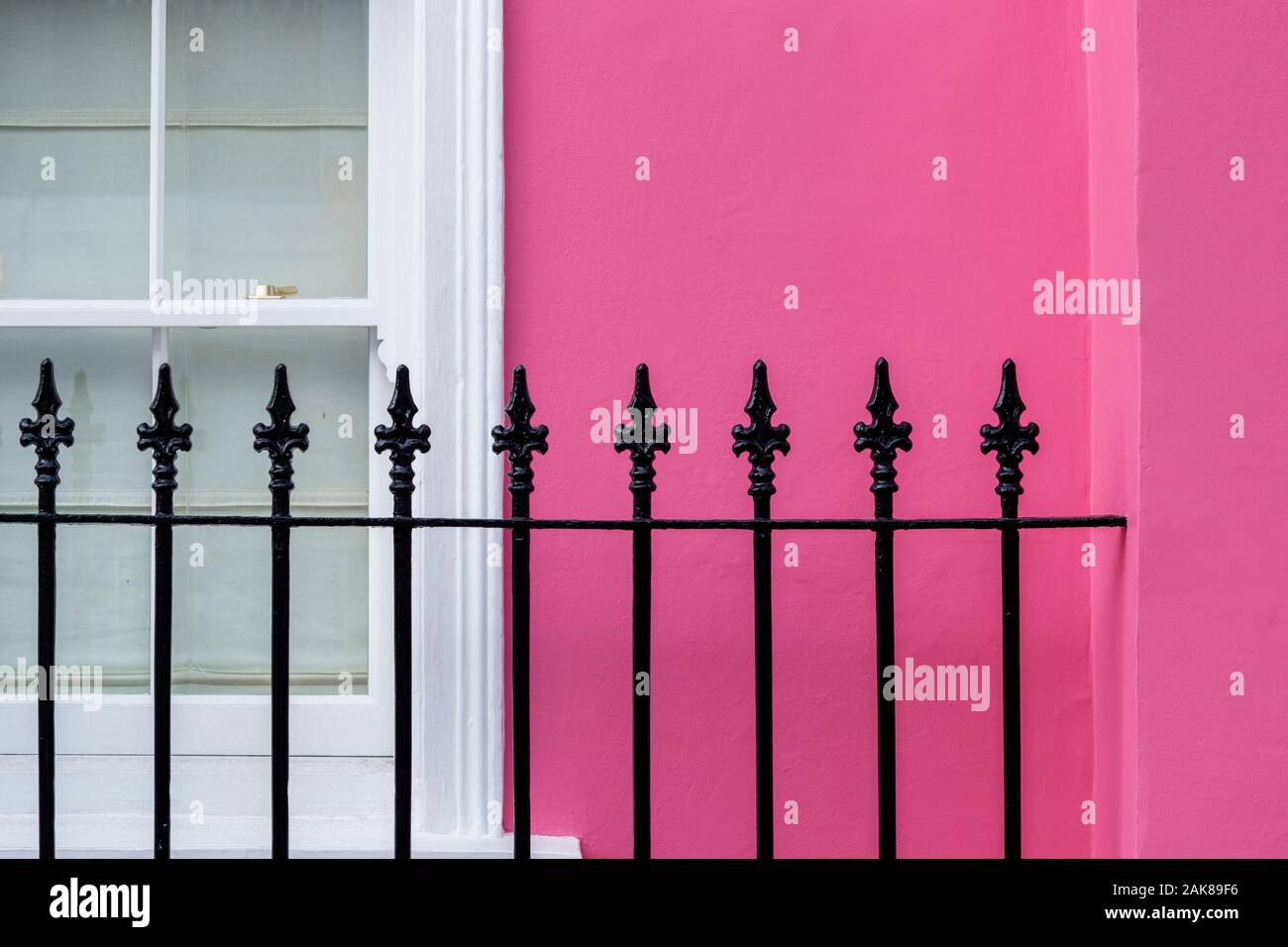 Colourful pink terraced house, window and wrought iron railings abstract. Chelsea, Royal Borough of Kensington and Chelsea, London, England Stock Photo