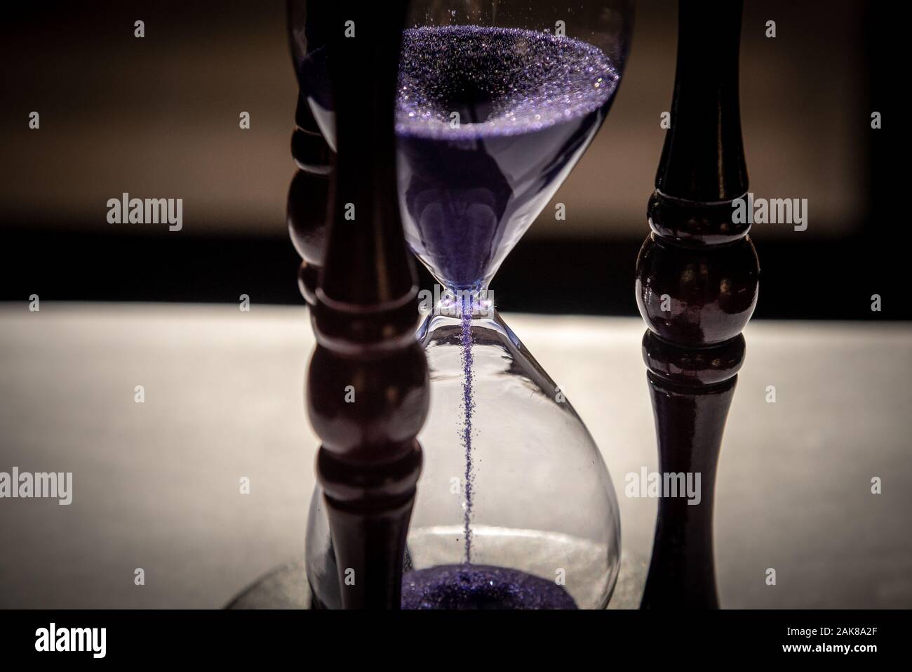 Closed up of sandglass or hourglass with violet, purple sand Stock Photo