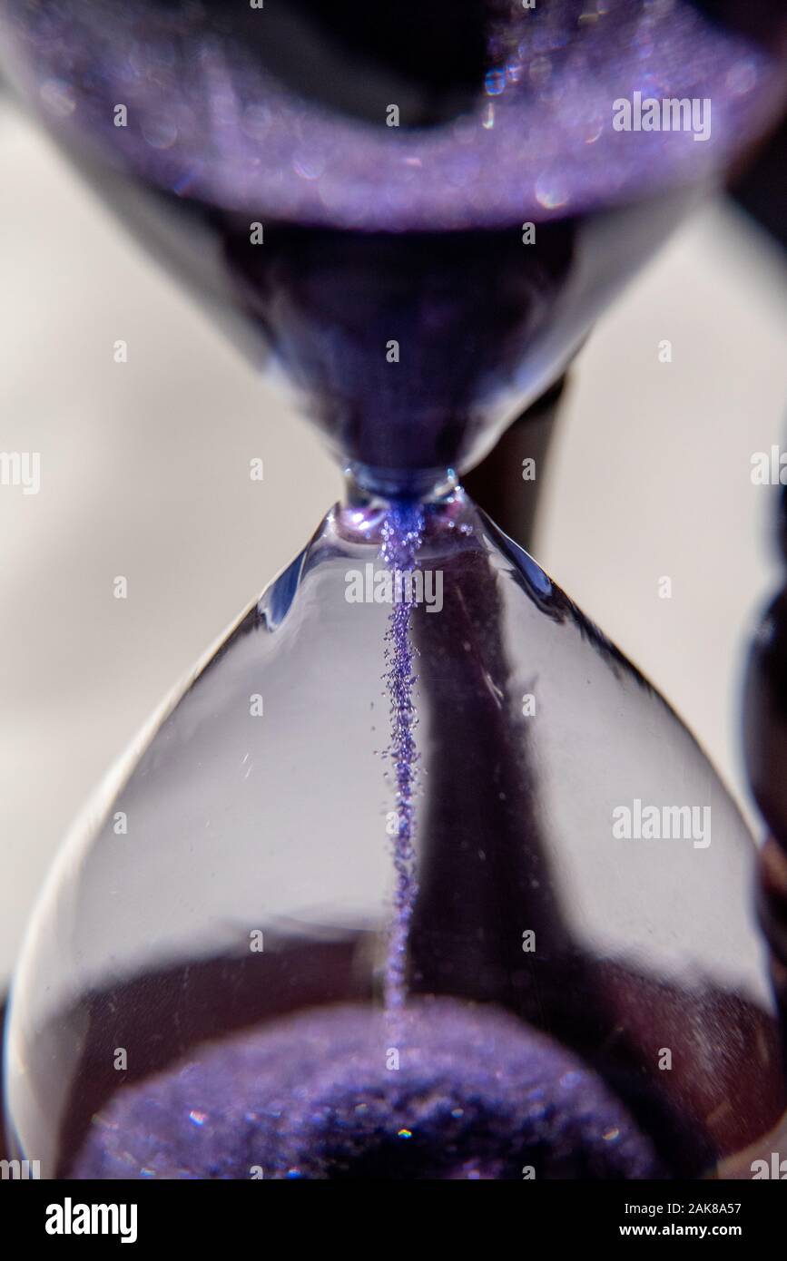 Closed up of sandglass or hourglass with violet, purple sand Stock Photo