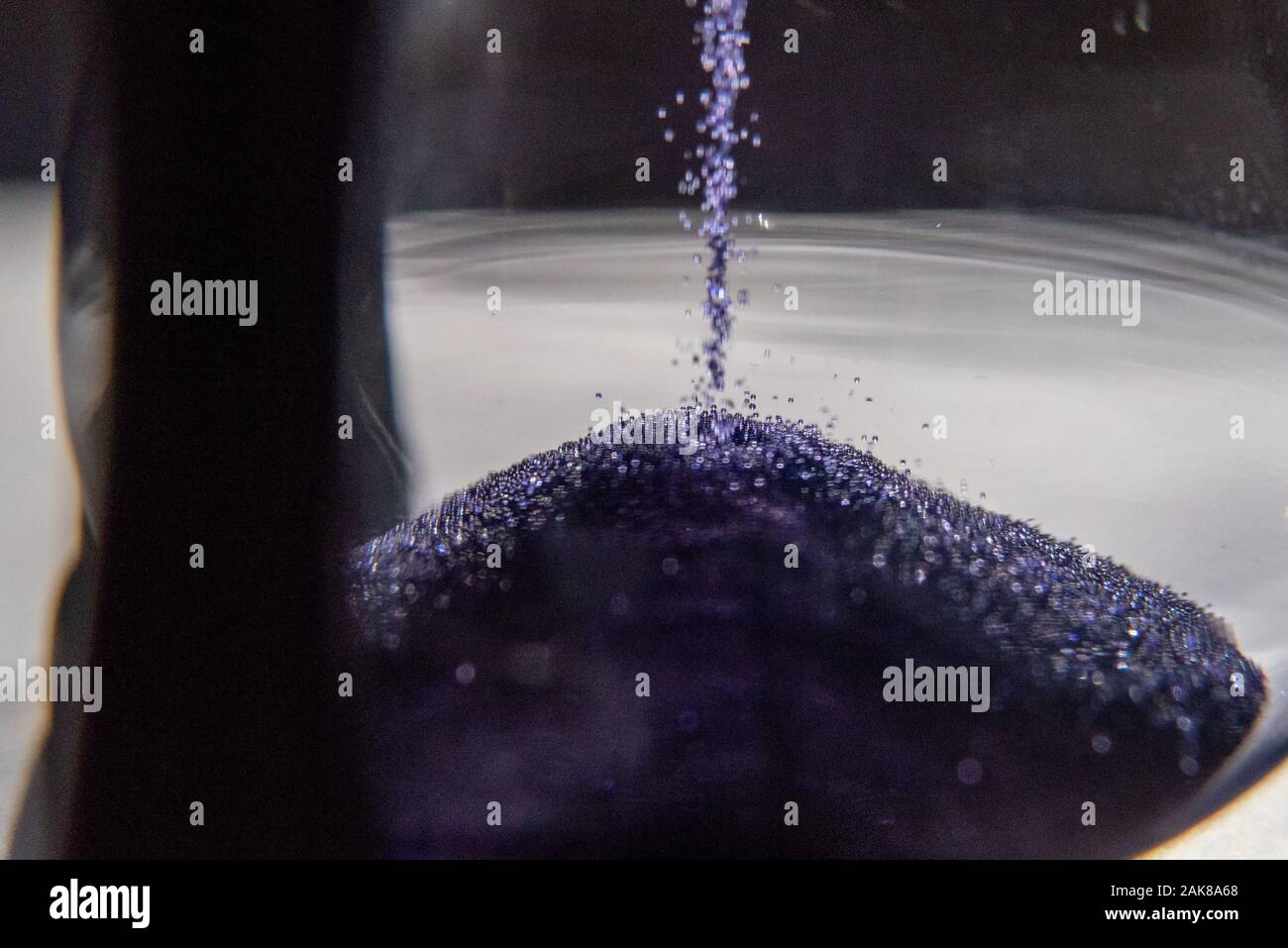 Closed up of sandglass or hourglass with violet, purple sand Stock Photo