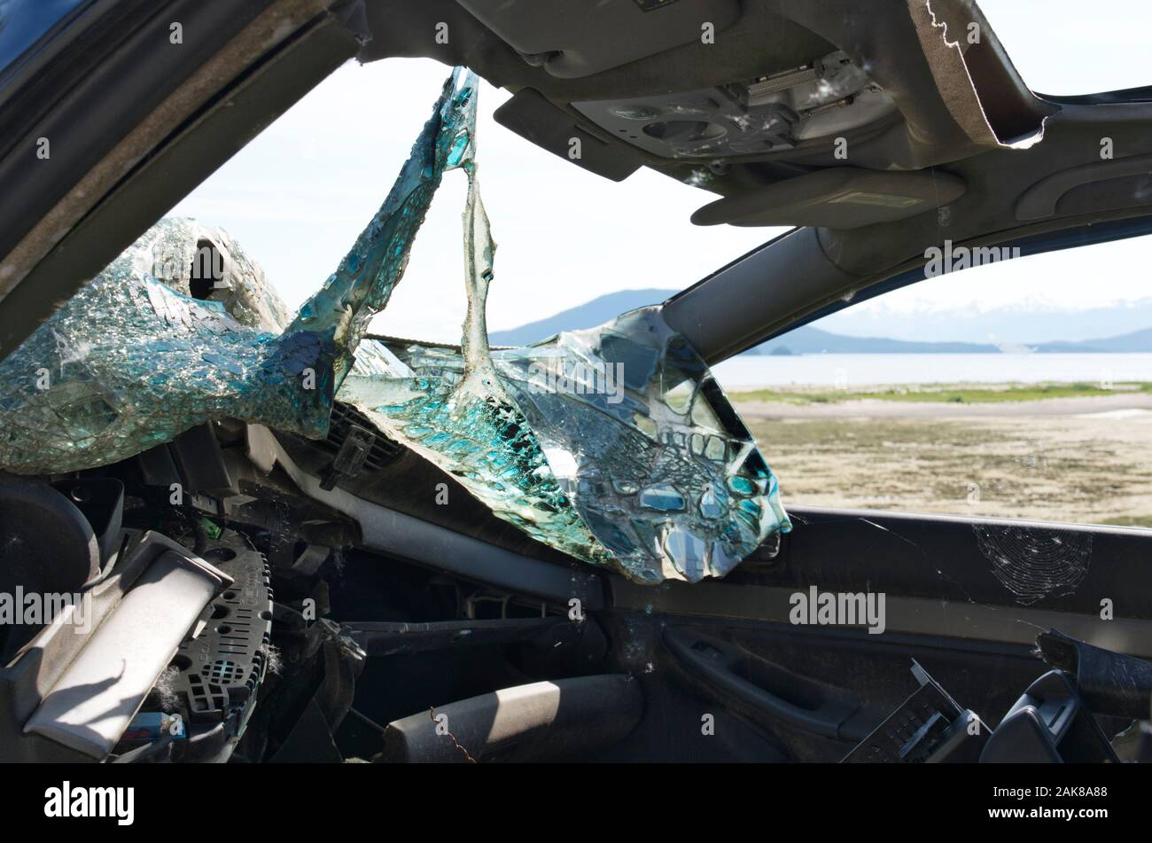 Aftermath of a car accident with a smashed windshield and bent vehicle frame as shown from the interior. Stock Photo