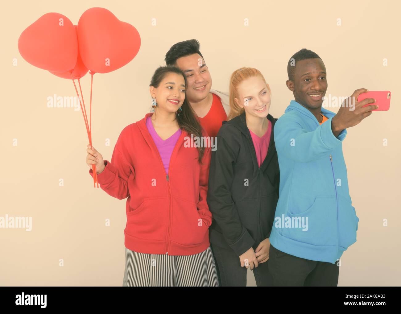 Diverse multi ethnic group of happy friends taking selfie and ready for Valentine's day together Stock Photo