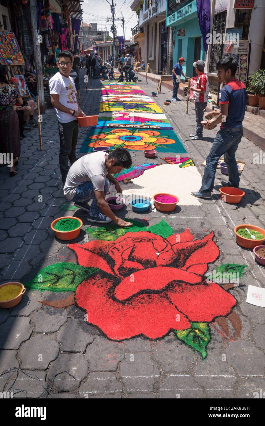 Santiago Atitlan, Guatemala - 30 March 2018: Local people making alfombra, colorful sawdust carpets with rose for Semana Santa, Easter on the street, Stock Photo