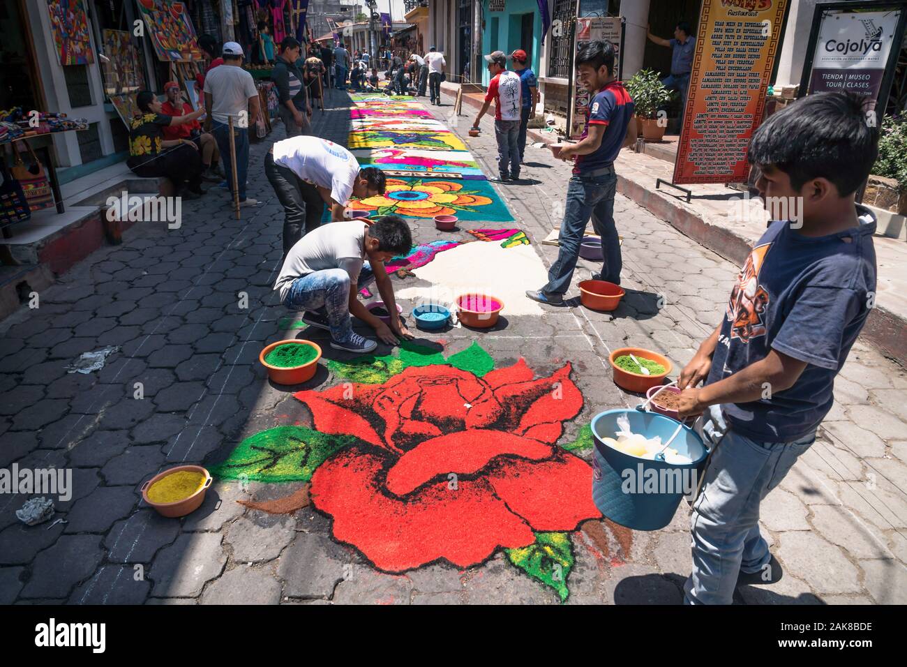 Santiago Atitlan, Guatemala - 30 March 2018: Local people making alfombra, colorful sawdust carpets with rose for Semana Santa, Easter on the street Stock Photo