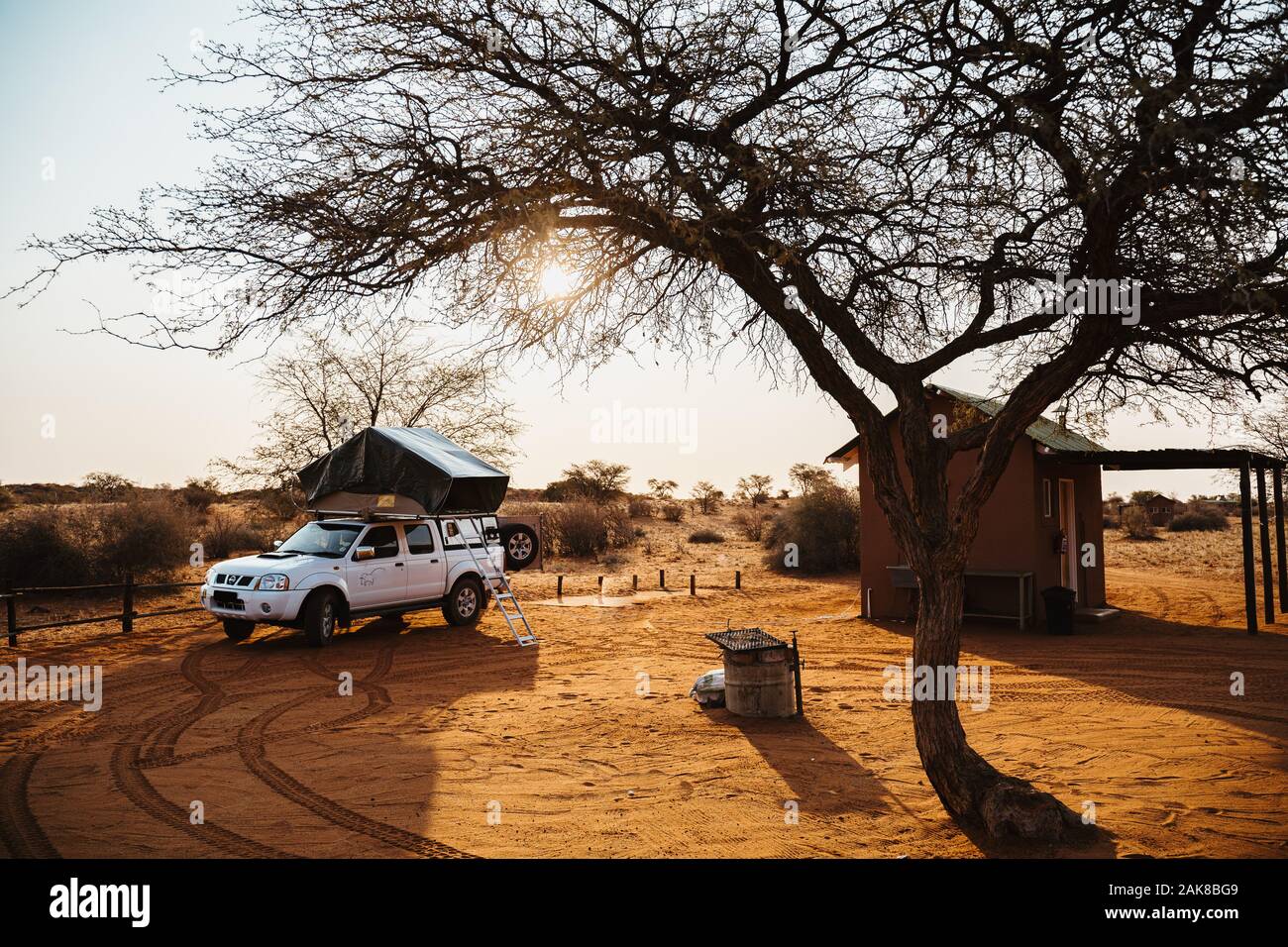 4x4 vehicle with roof top tent camping in Namibia desert during sunset