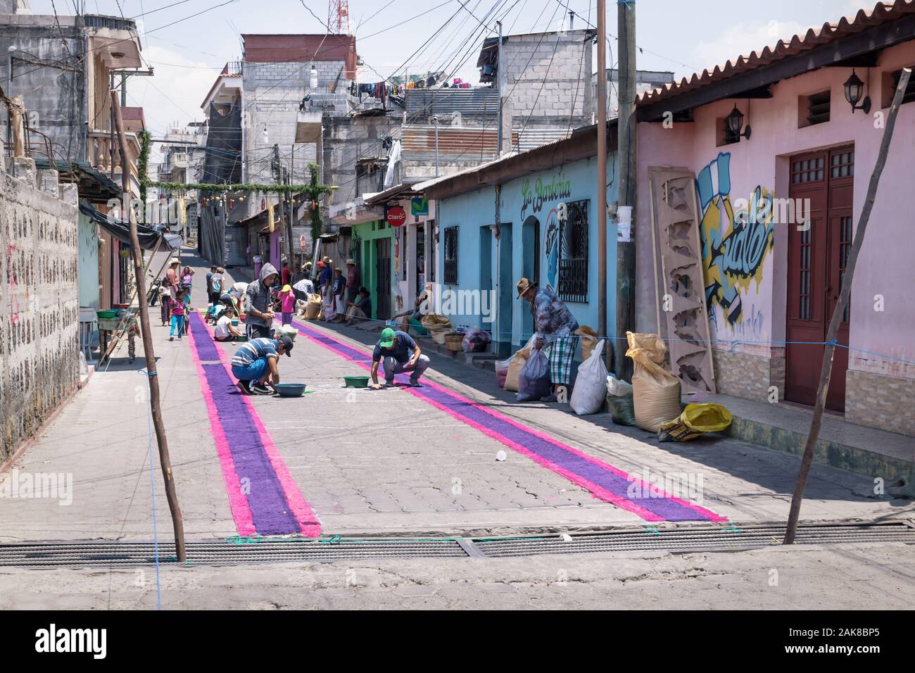Santiago Atitlan, Guatemala - 30 March 2018: Local people making alfombra, colorful sawdust carpets for Semana Santa, Easter on the graffiti street Stock Photo