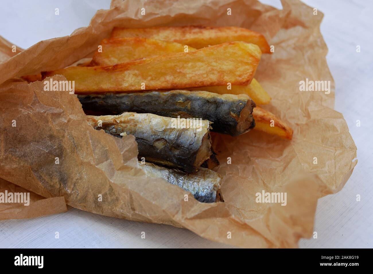 Fish and chips in a paper wrapper/ Yummy takeaway food/ Classic British fish and chips/ fast food Stock Photo