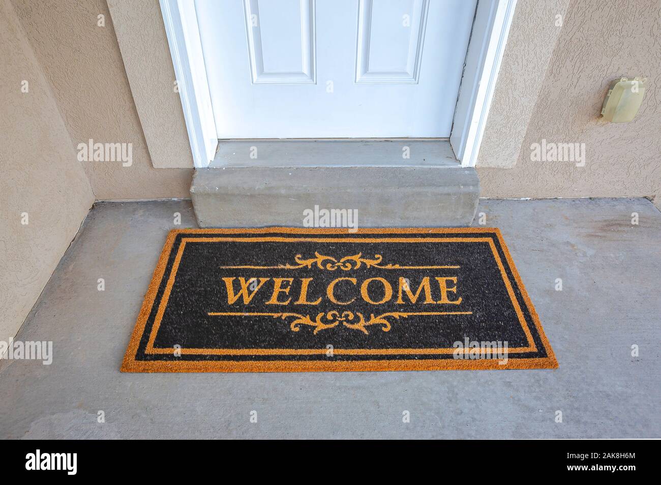 Black and brown doormat by the doorstep of home with white