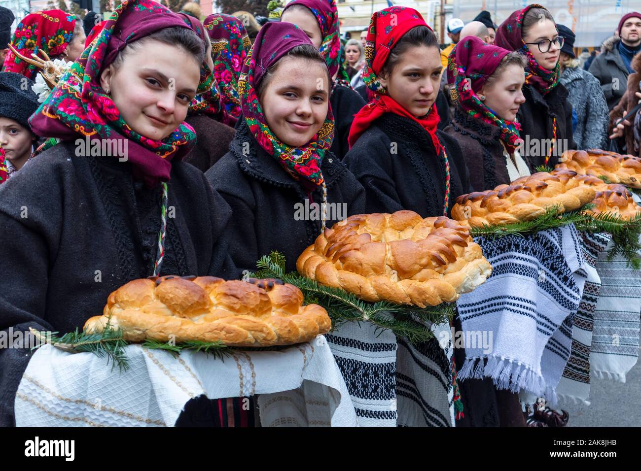 Marmatia Winter Customs and Traditions Festival - Young girls with beautiful head scarf, holding traditional bread Stock Photo