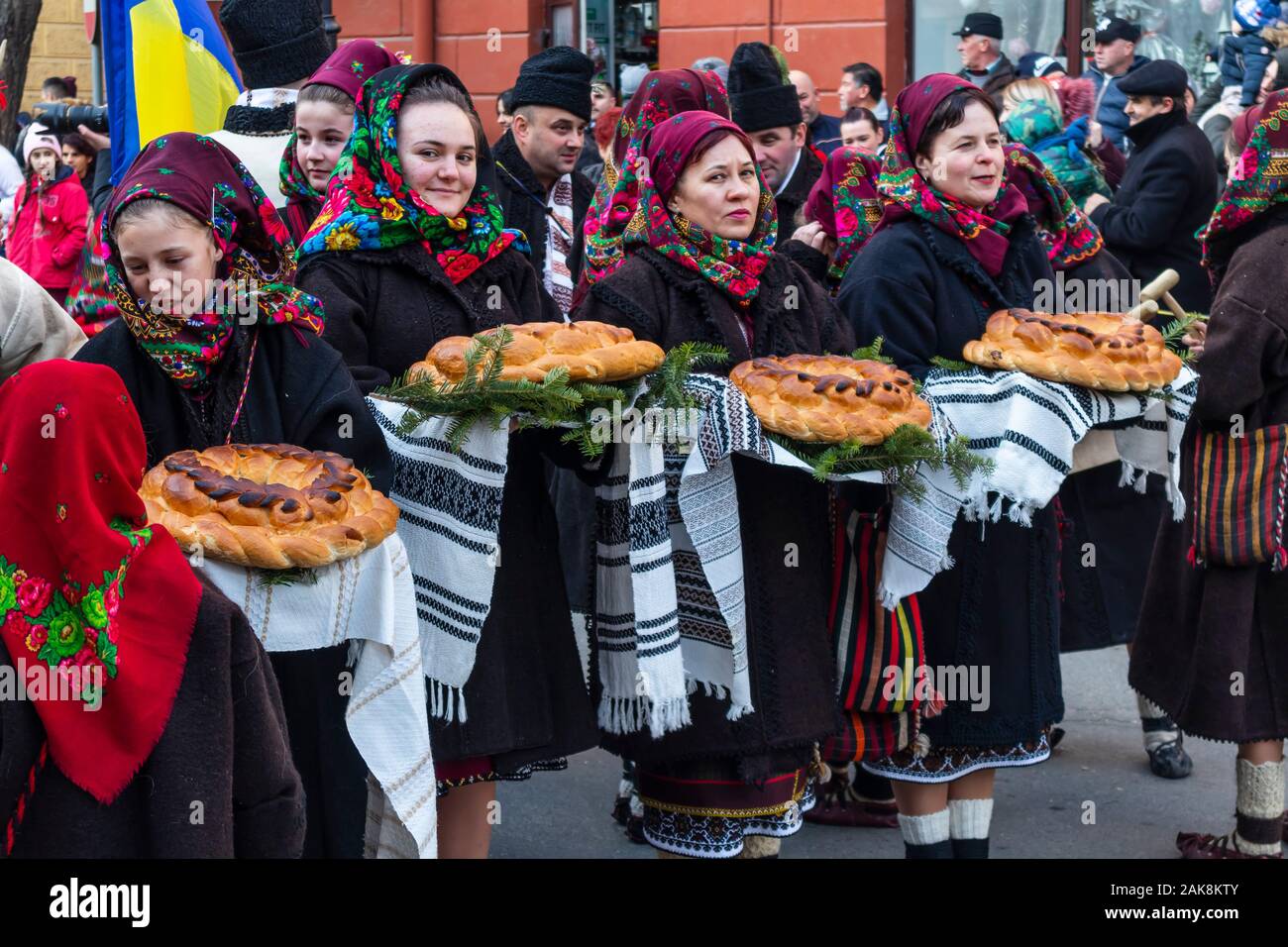 Marmatia Winter Customs and Traditions Festival - Young girls with beautiful head scarf, holding traditional bread Stock Photo