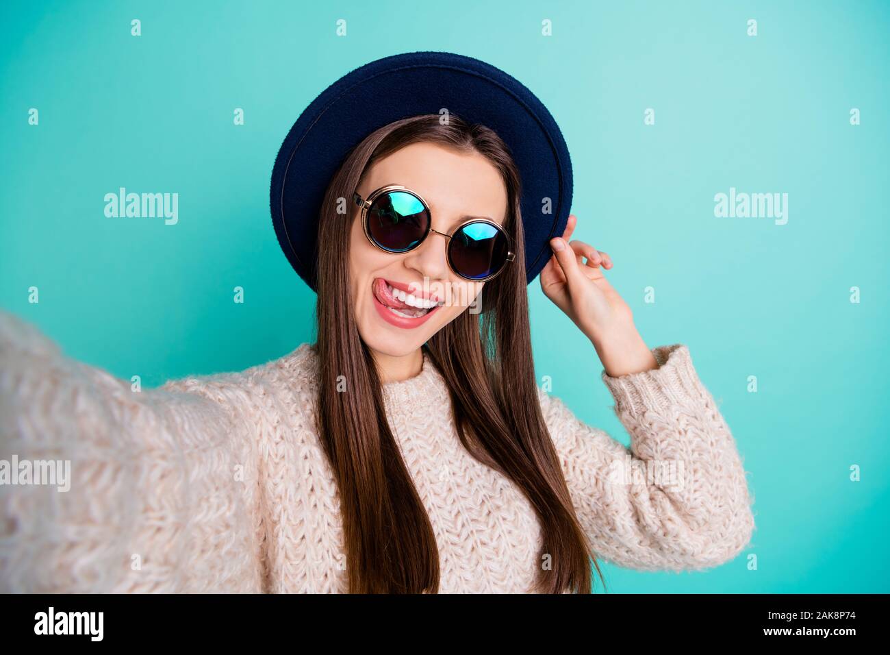 Close up photo of crazy foolish cute girl make self portrait blogging lick lips have fun wear knitted jumper isolated over teal turquoise color Stock Photo