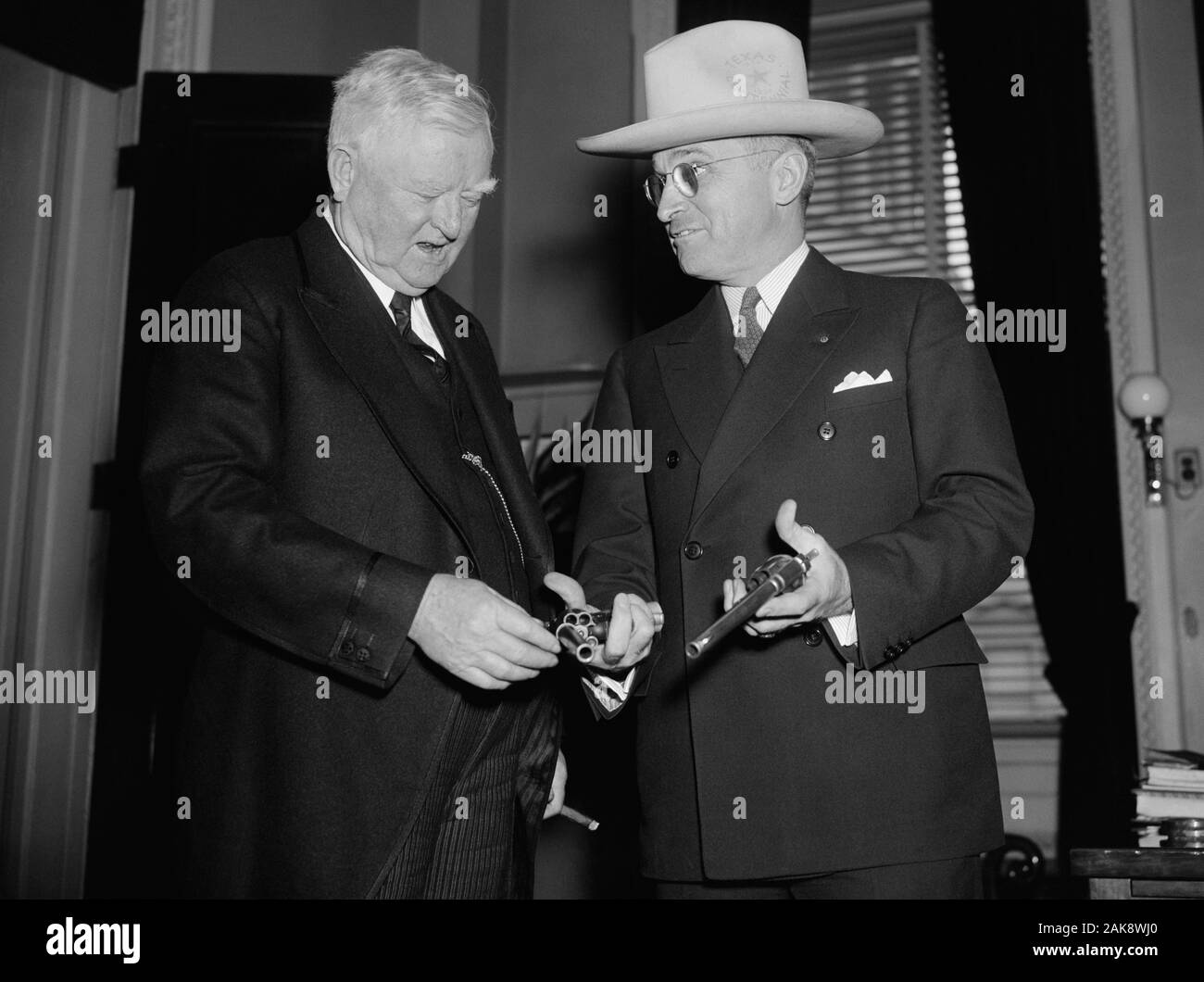 Vintage photo of US Vice President John Nance Garner (left) being shown a pair of 45-caliber pistols by Missouri Senator - and future President - Harry S Truman. The guns were said to have been once owned by the notorious outlaw Jesse James and had been obtained by Truman from the wife of a doctor who had been given them by Jesse’s brother Frank as payment for medical services. Photo by Harris & Ewing taken in Washington DC on February 17 1938. Garner (1868 – 1967) was the 32nd Vice President (1933 – 1941) and Truman (1884 – 1972) would later become the 33rd US President (1945 – 1953). Stock Photo