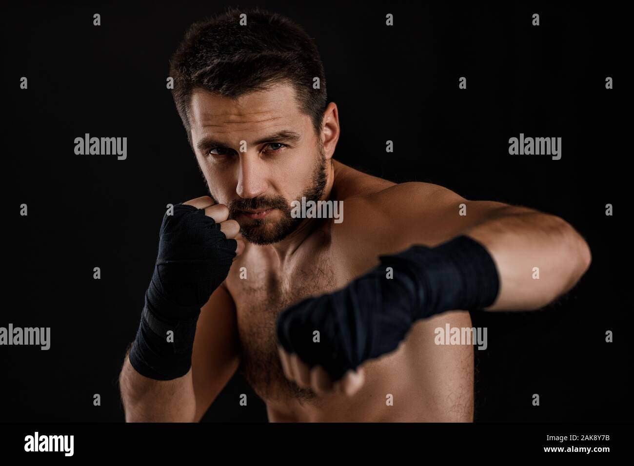 boxer man with bandage on hands training before fight and showing the