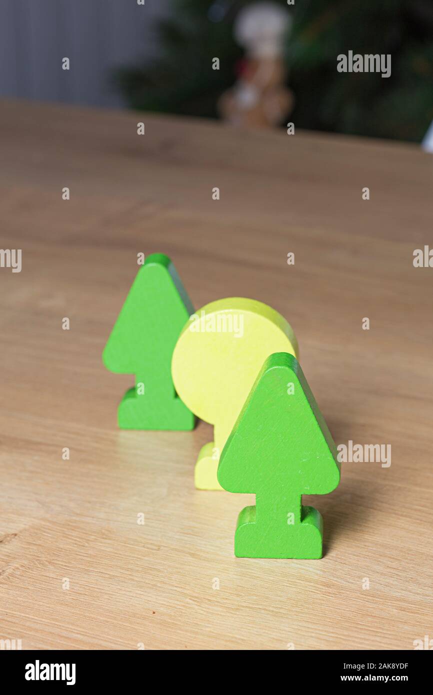 Green toy trees forest close up wooden surface on a dark background Stock Photo