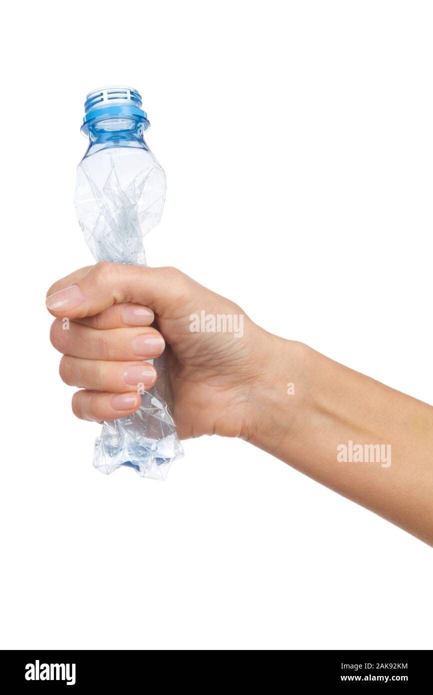 Closeup of woman's hand crushing an empty plastic bottle. Studio shot isolated on white Stock