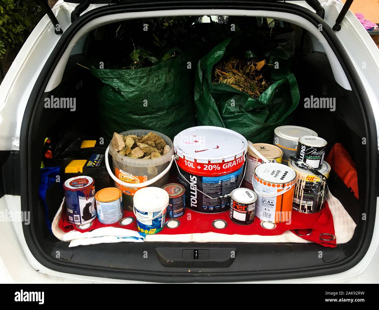 Paint buckets to recycle, stocked in a car trunk, Lyon, France Stock Photo