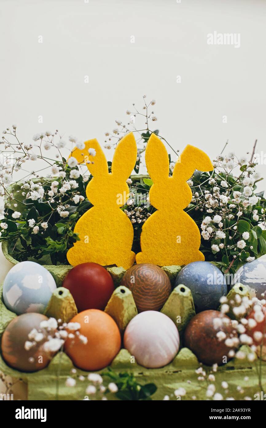 Stylish easter eggs in carton tray, yellow bunny in nest of spring flowers  on yellow paper, space for text. Natural dyed easter eggs and rabbit decora  Stock Photo - Alamy