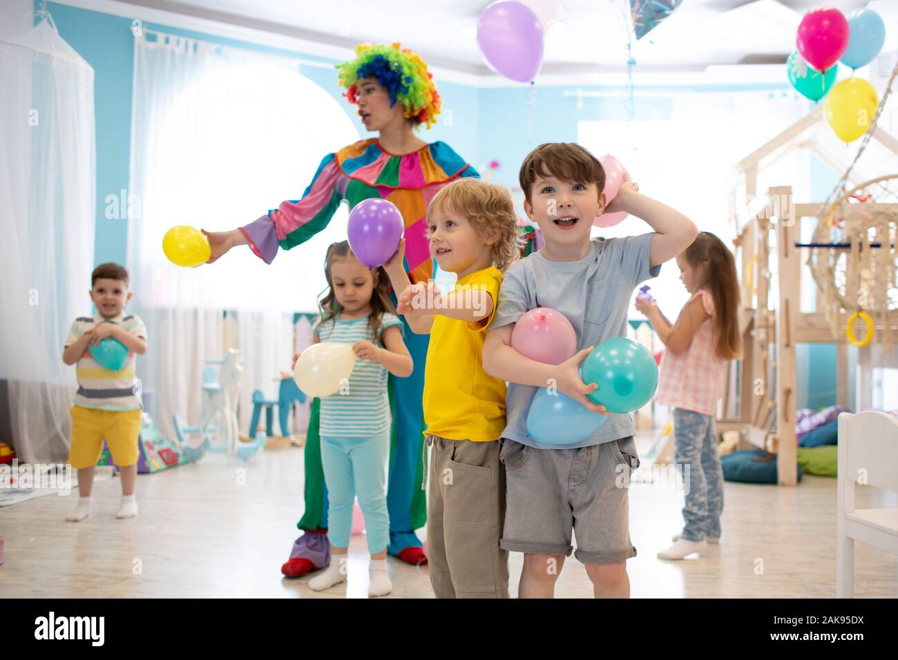 Clown entertains kids at children's party in club Stock Photo