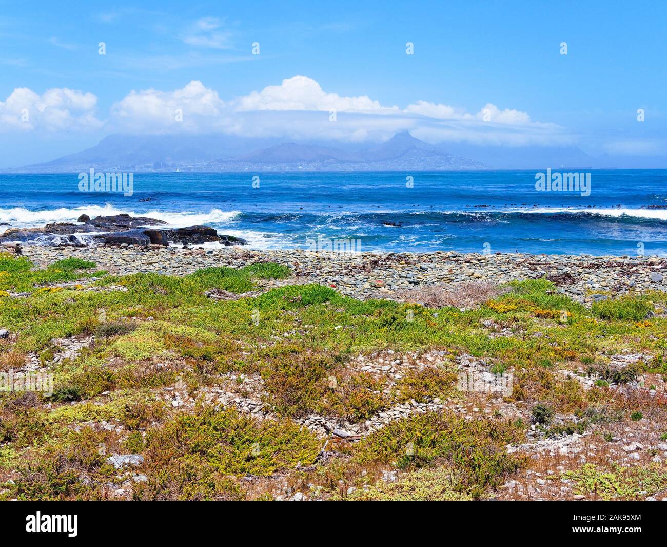 From the shore of Robben Island, across Table Bay to a distant, cloud covered Cape Town Stock Photo