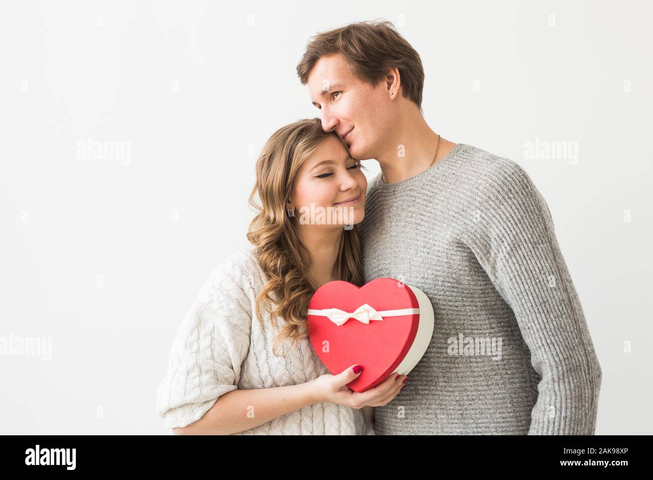 Valentine's day, holiday and gift concept. Happy young couple with ...