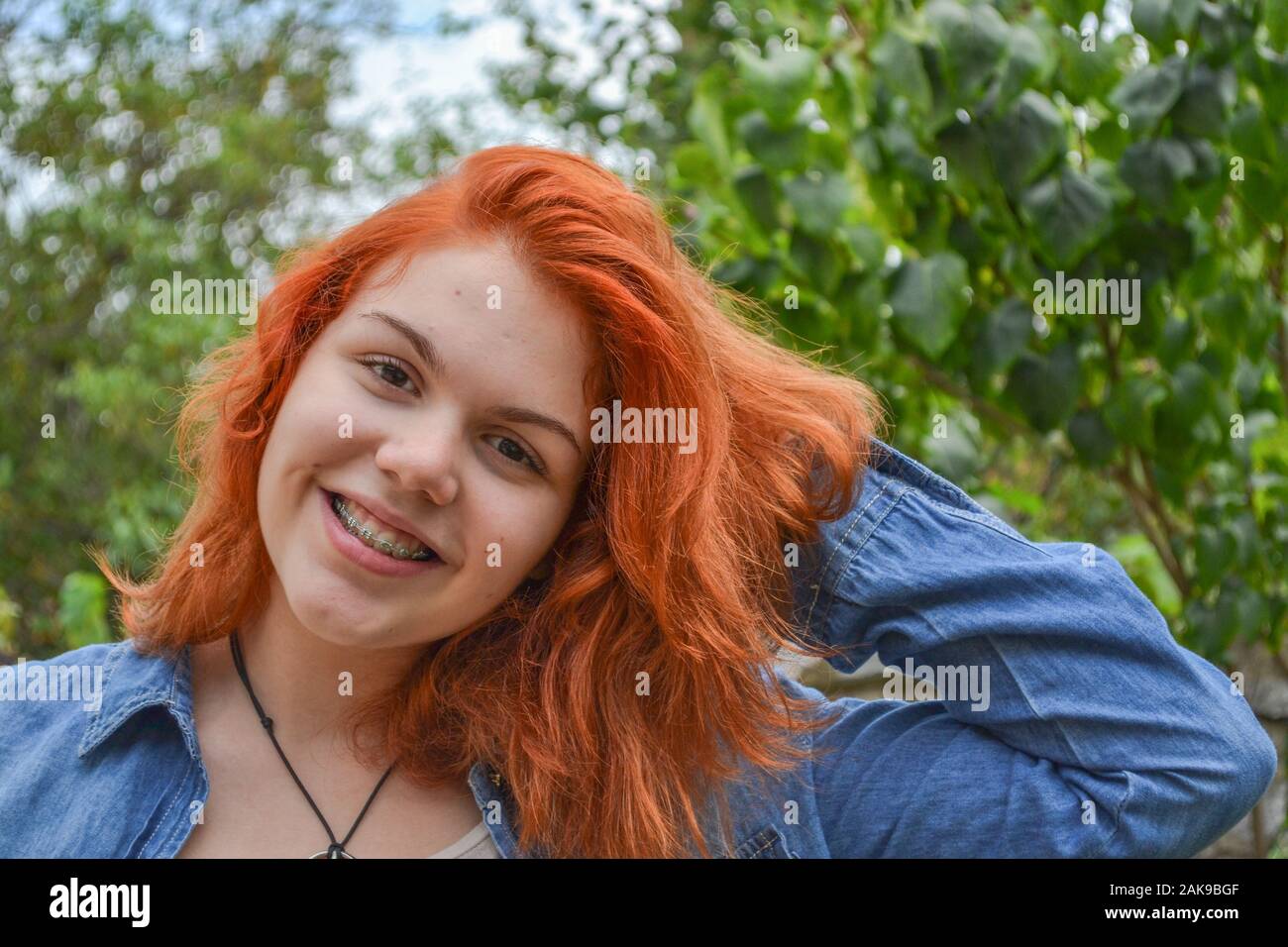 Girl with dental braces, dyed her brown hair orange for the first time Stock Photo