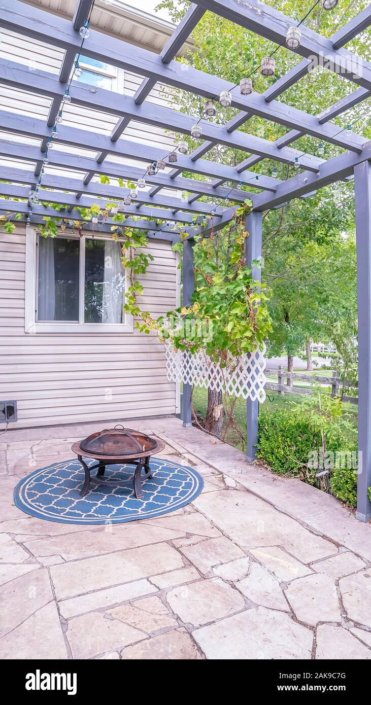 Vertical frame Paved exterior patio with wooden pergola near sunset Stock  Photo - Alamy